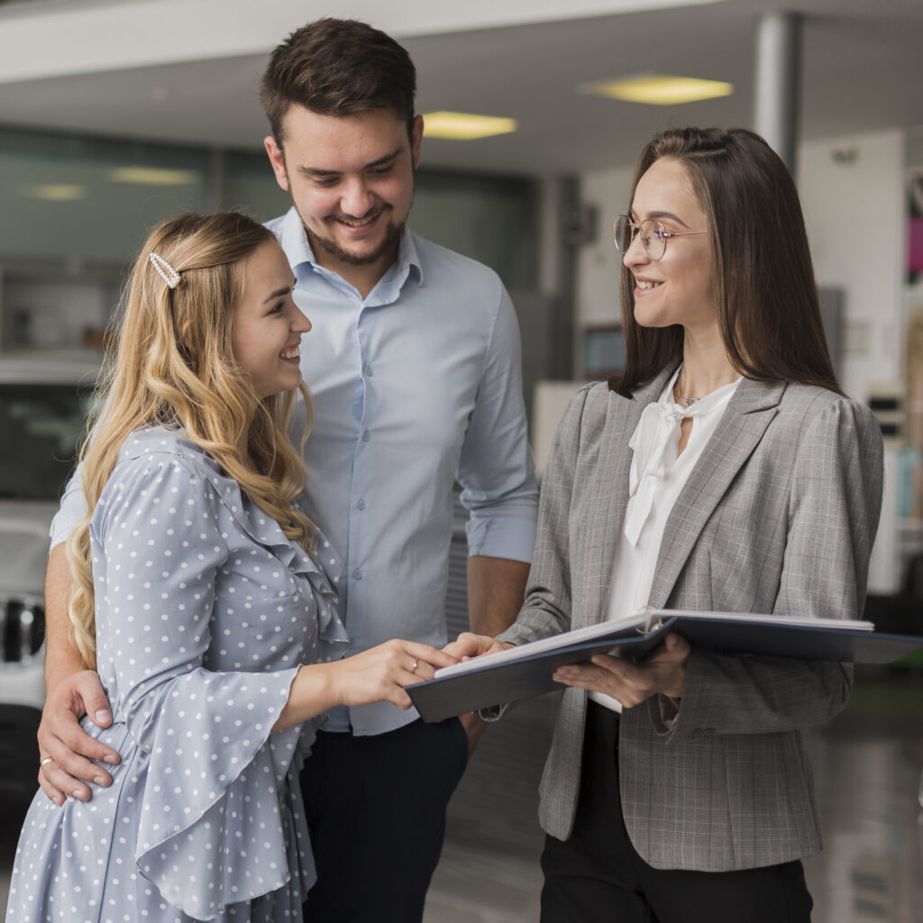 happy-couple-talking-with-car-dealer